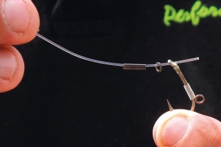 Na stiff line 0,65 mm nasunieme carp crimps, krúžok a vsunieme ho do očka háčika.