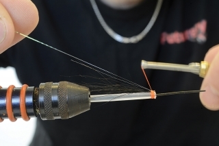 5. Pri očku háčika pripevnite vlákno Crystal Flash, asi v jeho polovičke, a potom prednú časť ohnite dozadu tak, aby sa vytvorili dva lúče.