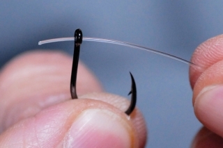 Cez očko háčika Hayabusa K1 prevlečieme fluorocarbonový vlasec.
