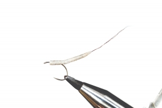 1. Háčik prepichneme cez telíčko Mayfly Tube Body a upneme do zveráčika.