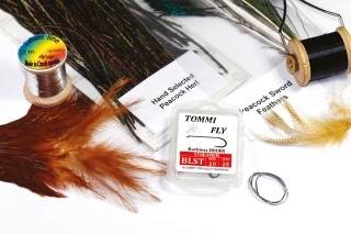 Materiály:
väčší háčik s predĺženým ramienkom, čierna viazacia niť, ploché olovo, pár lúčov z „meča“ páva, perie z chvostového pera páva, strieborná lametka, pierko z hrdzavej sliepky, pero káčera.