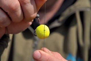 Na boilies umiestnite zarážku a poistíte ju niekoľkými uzlami, aby pevne držalo, koniec zatavte zapaľovačom.