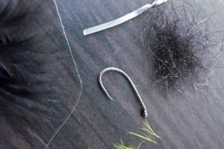 Viazacie materiály:
Háčik s krátkym ramienkom, čierne marabou, perleťová lametka, čierny dabing, chvost z veveričky, olovený pásik.