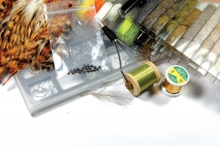 Materiály:
Jigový háčik, volfrámová guľôčka, olivová viazacia niť, zlatá lametka, hrdzavé perie zo sliepky, zelený dabing, CDC pierko, oranžovo-zelený spectra dabing.