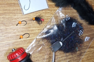 Materiál: červená vlna, čierna viazacia nitka, silon 0,10 mm, háčik Dohiku 302 veľkosť 12, Spectra Dubbing, čierny skalp z kohúta, oranžová mosadzná hlavička 2,8 mm.