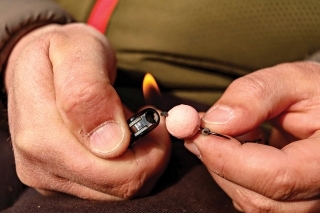 Koniec šnúrky zastrihnite cca 1 cm za popkou a pomocou zapaľovača šnúrku roztavte tak, až sa vytvorí guľôčka.