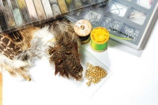Materiály: 
hrubší mokrý háčik, volfrámová guľôčka, tmavšia viazacia niť, zelená niť na zadoček, 2 pierka z jarabice, hnedastá srsť zajaca.