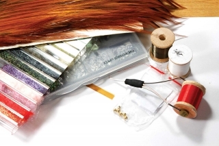 Materiály:
jigový háčik, volfrámová guľôčka, tmavo-olivová niť, biela niť, červená niť, hrdzavý kohút, páví dabing a vinylový pásik.
