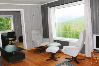 Obývačka s veľkým oknom a pekným výhľadom do údolia.